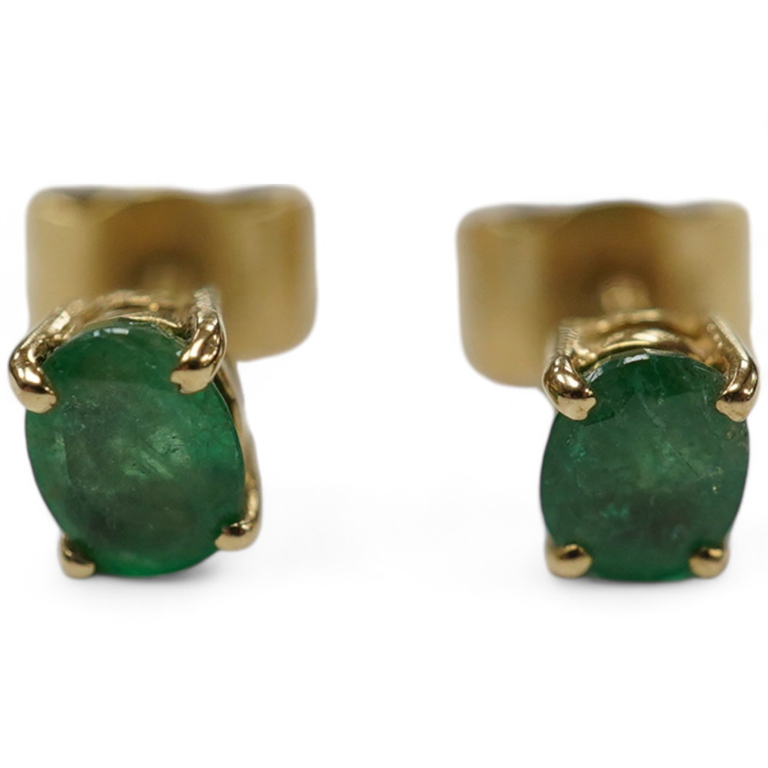 A pair of 9ct and solitaire oval cut emerald set ear studs, gross weight 1.2 grams. Condition - poor to fair